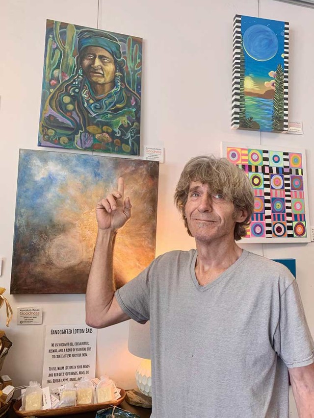 Artist Robert Maresh shows one of his paintings, for sale in the Community Market. Photo: Susan Dyer Reynolds