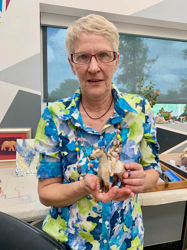 Artist Ute holds one of her clay figures.