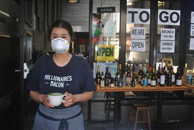 Mai Homsriprasert shows off a freshly made matcha latte with some beautiful latte art, working the takeout shift for Blackwood on Chestnut Street.